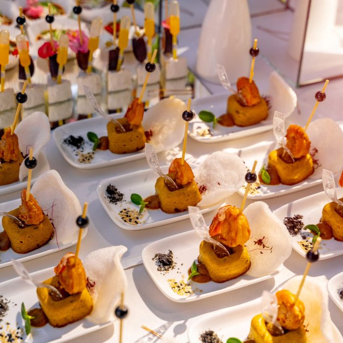 Luxury food on wedding table. Small appetizers on white plates. raw with snacks. Closeup.