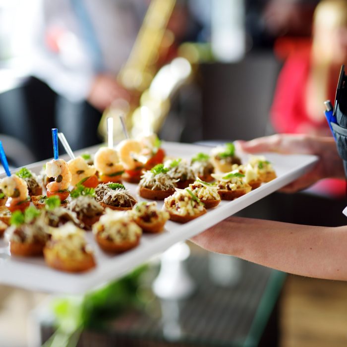 Waiter carrying plates with meat dish on some festive event, party or wedding reception
